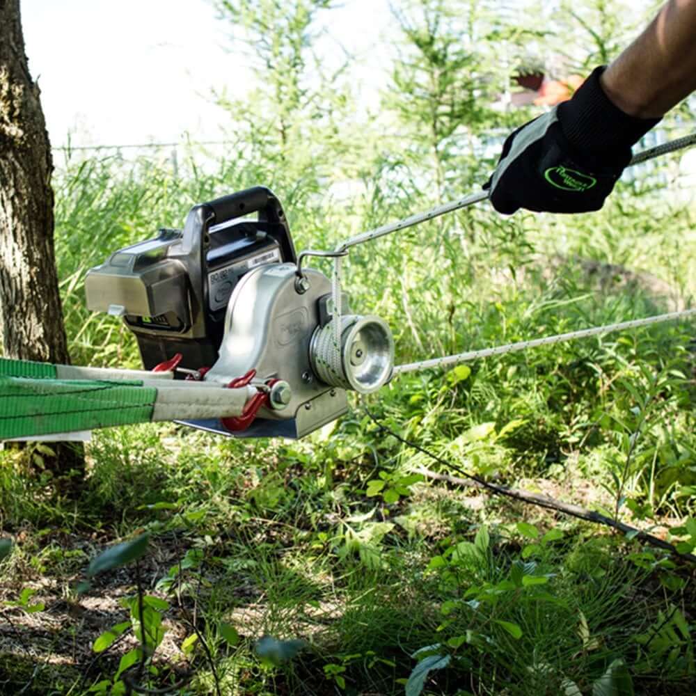 Portable winch PCW3000-LI-K in action, demonstrating heavy load hauling capability in outdoor settings.