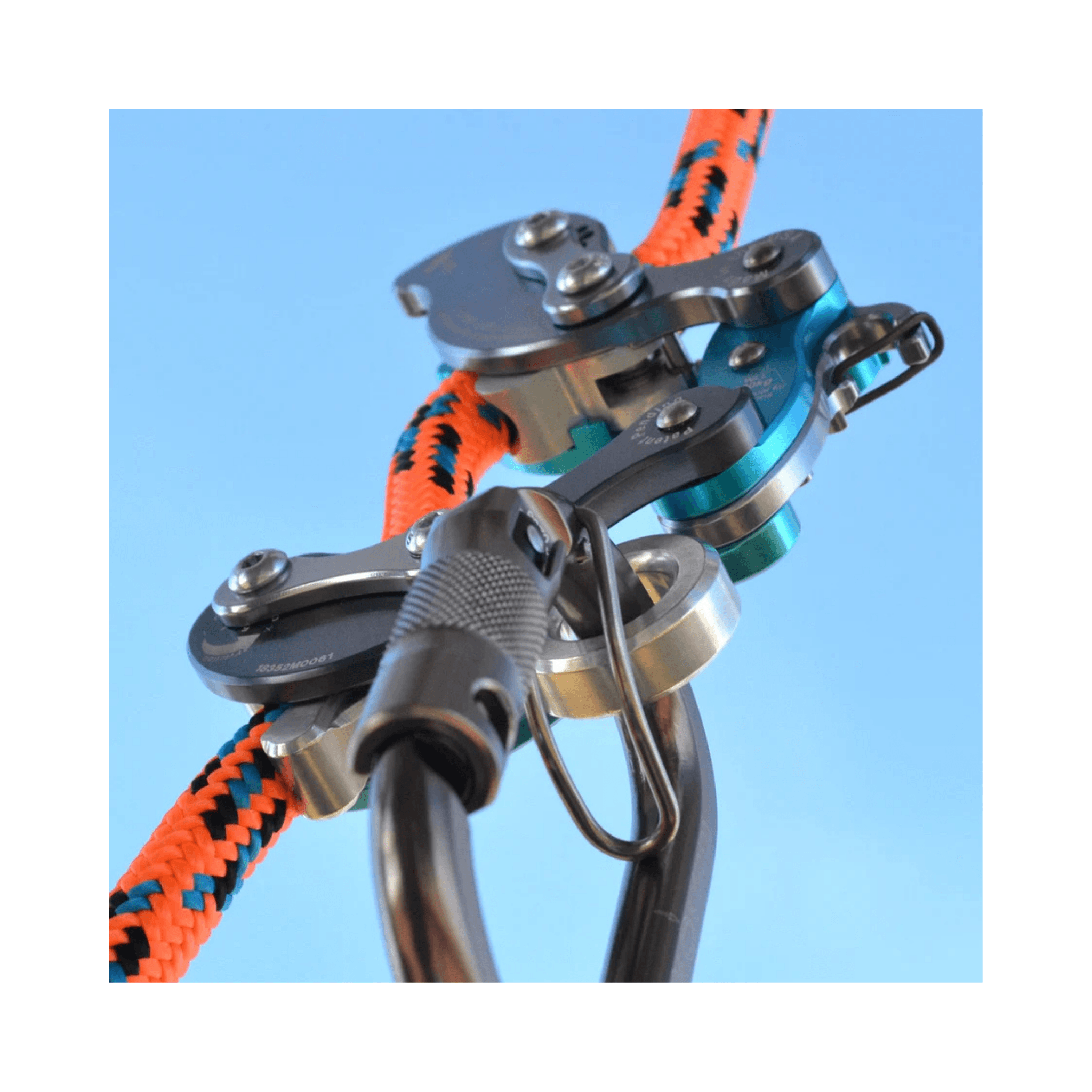 Akimbo Belay Device attached to colorful climbing rope, showcasing its design for efficient climbing systems.