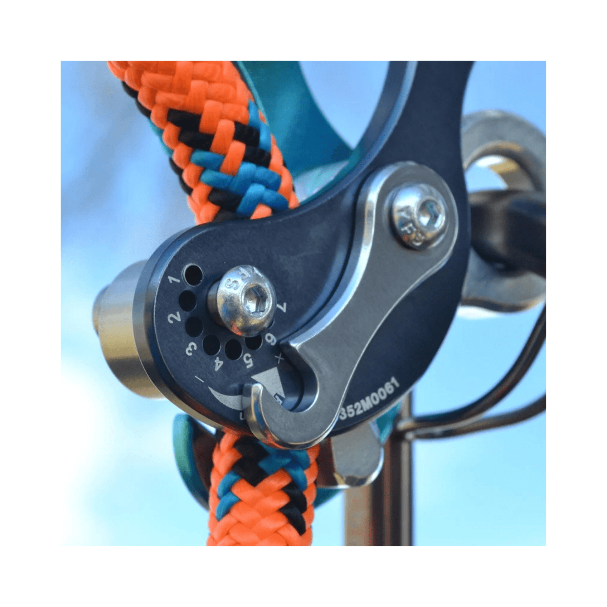 Close-up of the Rock Exotica Akimbo Belay Device showing the intricate friction mechanism and colorful ropes.
