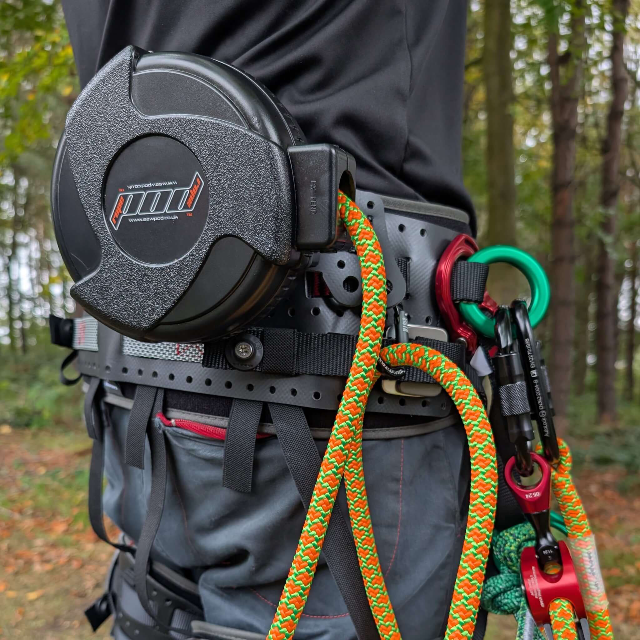 RopePod Retractable Lanyard System attached to a harness with colorful lanyard in a forest setting.