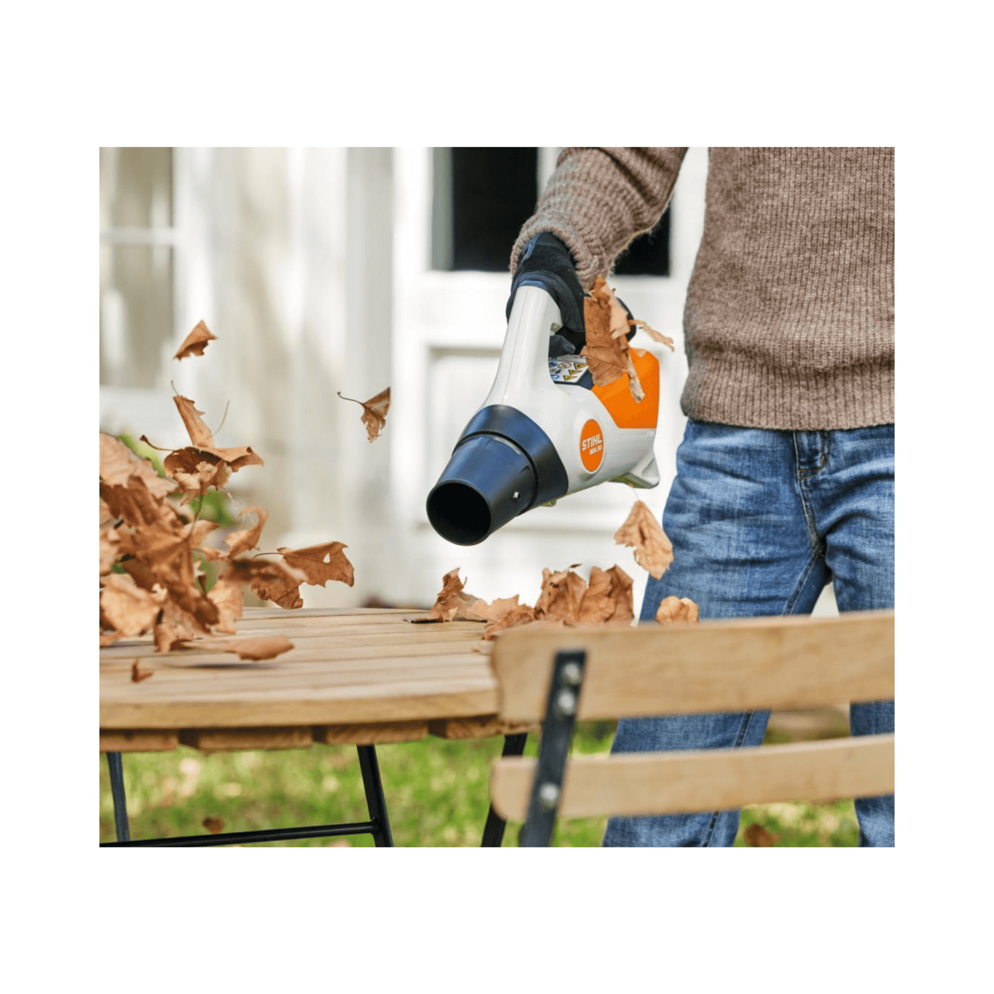 BGA 30 Cordless Leaf Blower in action clearing leaves from a garden table, ideal for home gardeners.