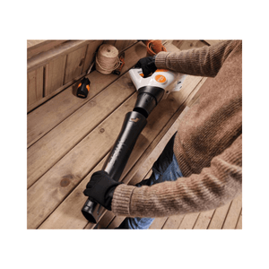 BGA 30 Cordless Leaf Blower being operated by a person in a cozy sweater on a wooden porch.