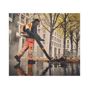 Person using BRA 600 Cordless Backpack Leaf Blower to clear leaves in an urban environment.