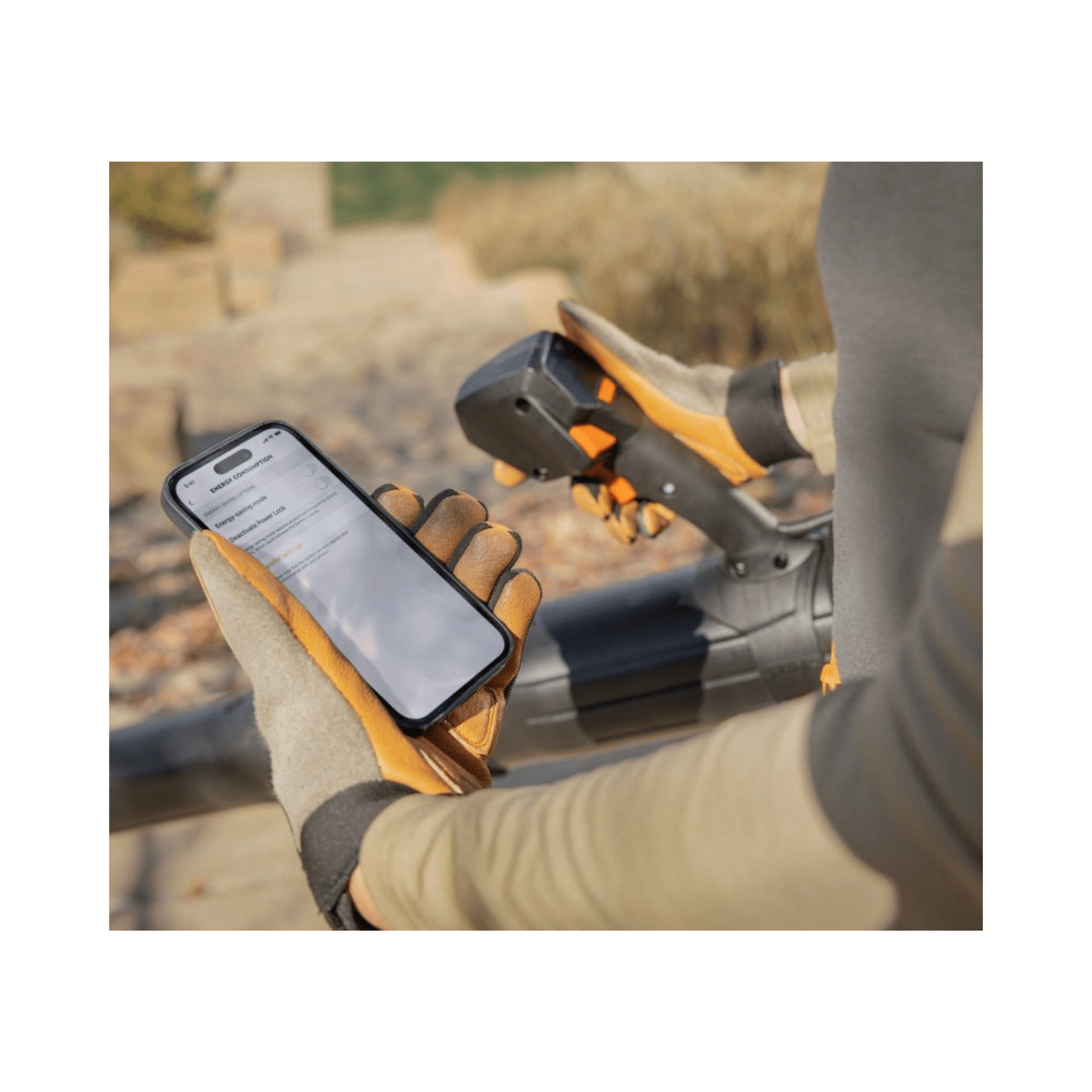 User operating the BRA 600 Cordless Backpack Leaf Blower while checking a smartphone outdoors.