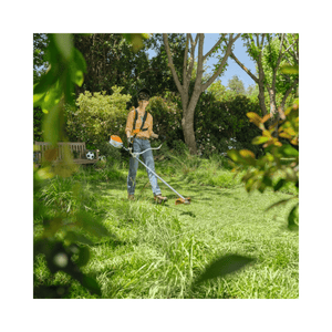 A person using the FSA 80 Cordless Trimmer to maintain a lush green garden.