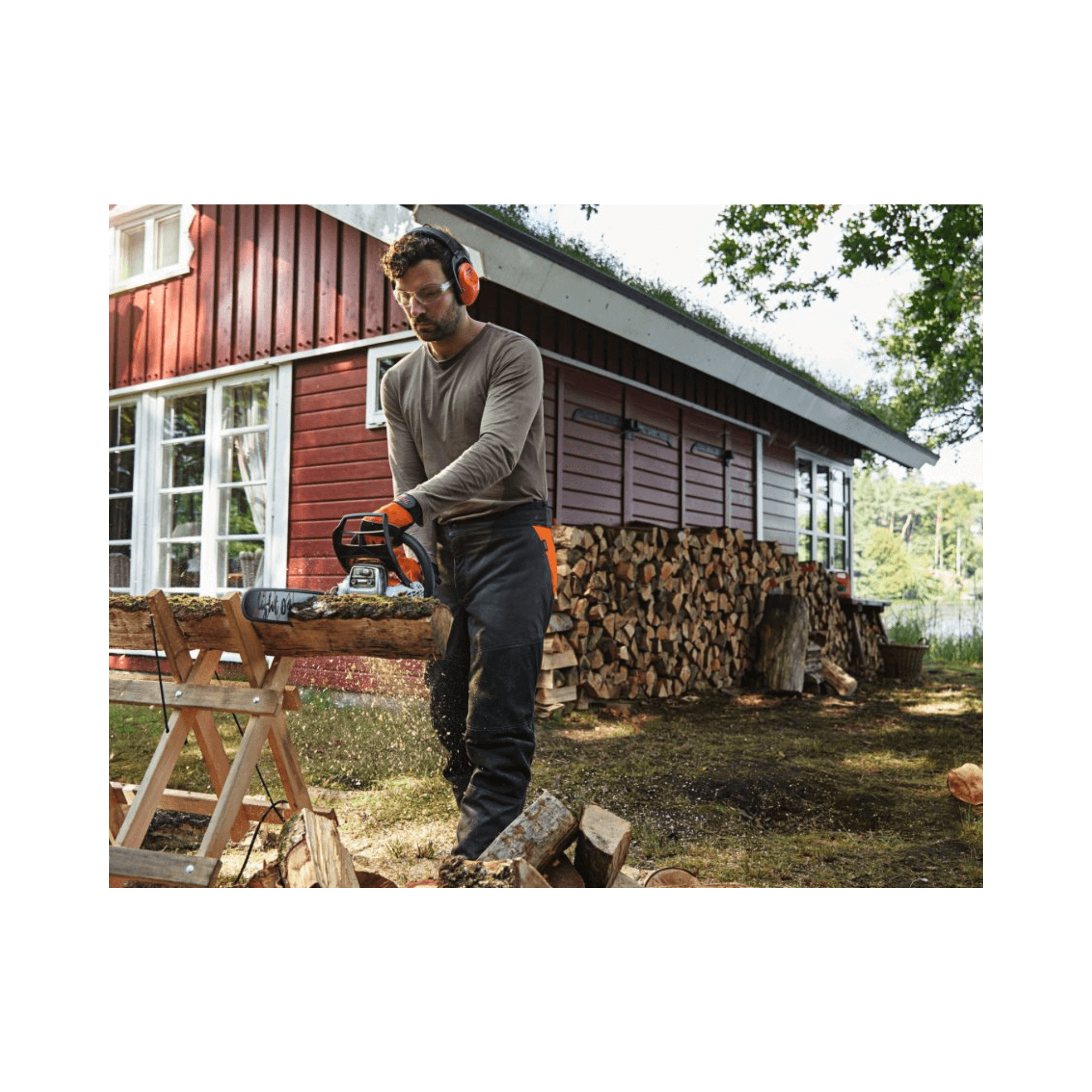 Man using STIHL MS 182 petrol chainsaw for cutting wood outdoors near a shed.
