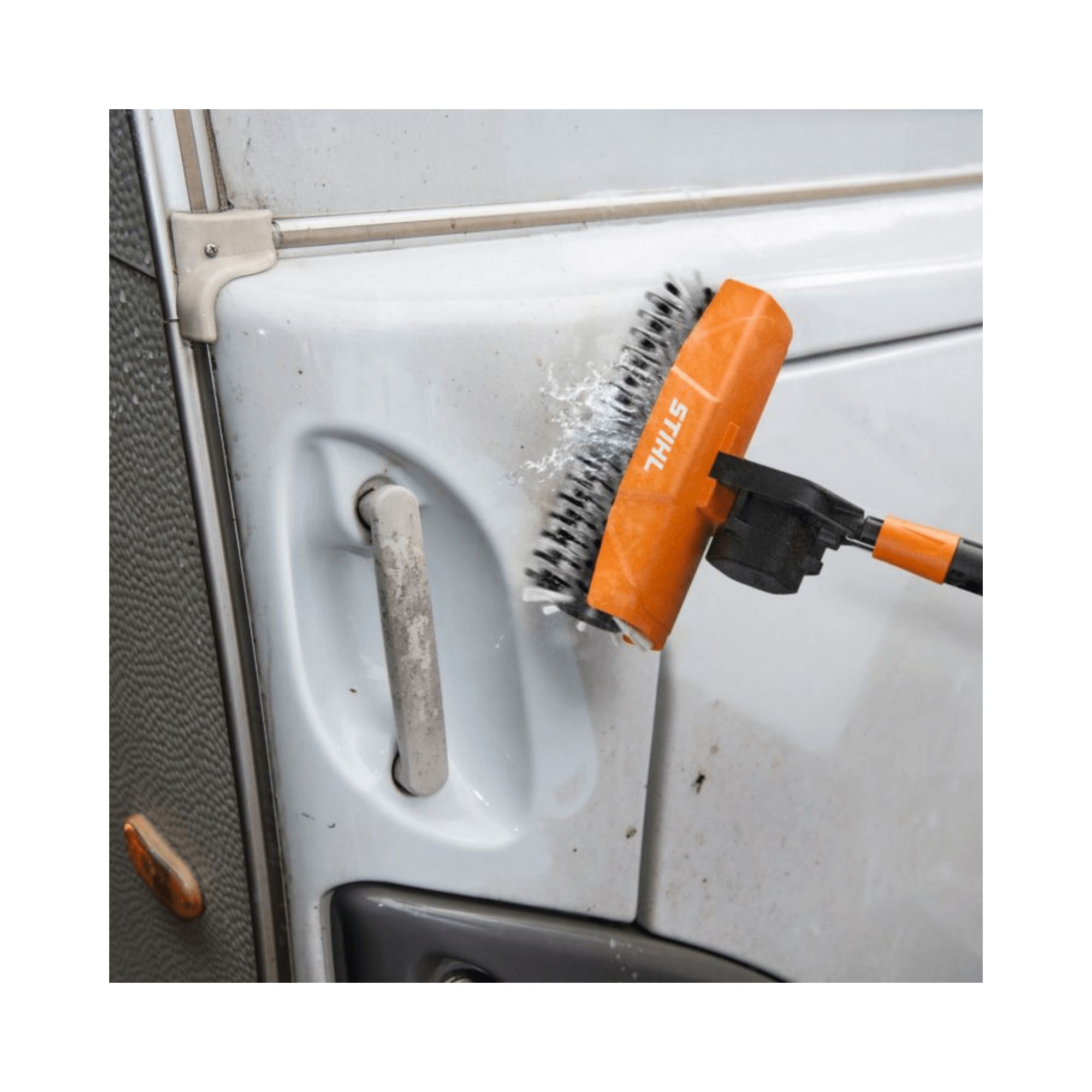 Rotating roller brush cleaning delicate surface of a vehicle door with pressure washer attachment