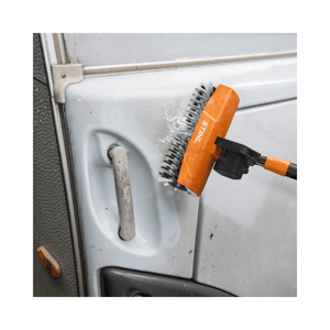 Rotating roller brush cleaning delicate surface of a vehicle door with pressure washer attachment
