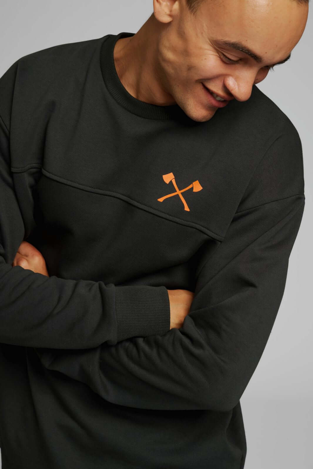 Man wearing STIHL TIMBERSPORTS Small Axe Sweatshirt with crossed axes design, showcasing lumberjack pride.