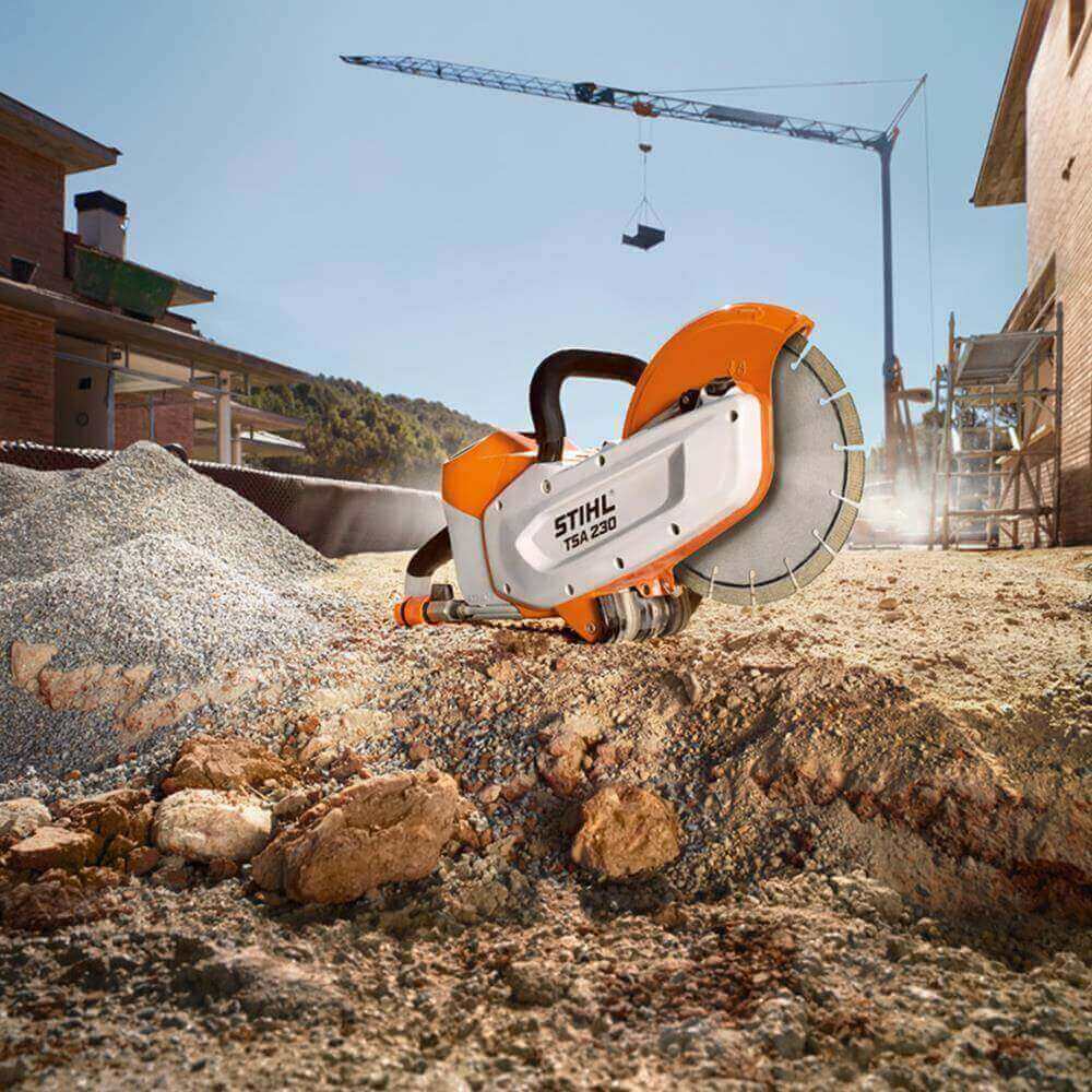 Powerful STIHL TS 420 cut-off saw resting on construction site gravel, ready for tree surgeon use.