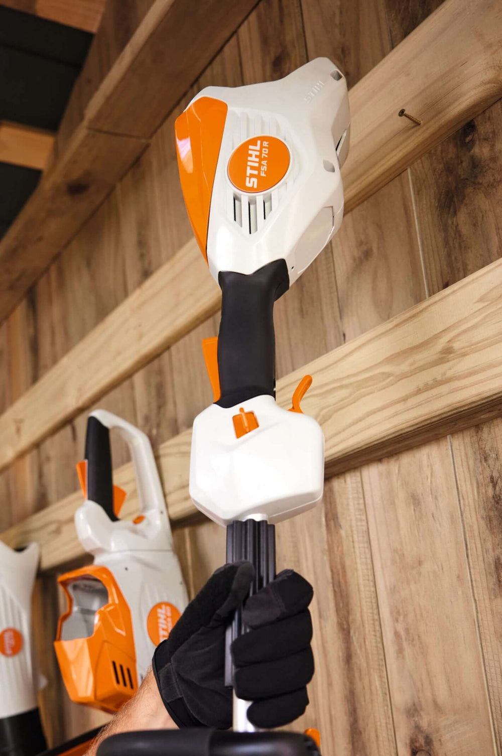STIHL FSA 70 R Cordless Strimmer being held by a user, showcasing its ergonomic design and powerful build.