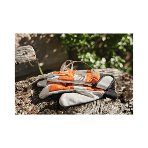 STIHL FUNCTION SLIM safety glasses and gloves on log, ideal eye protection for tree surgeons and outdoor work.