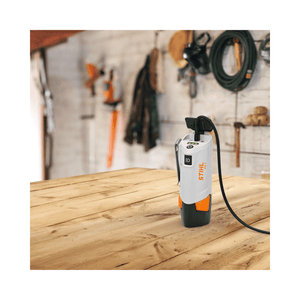 STIHL PS 1 Power Bank and Charger on a wooden table, ideal for tree surgeons and outdoor enthusiasts.