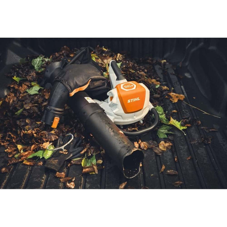 STIHL SHA 140 cordless leaf vacuum shredder next to leaves in a truck bed, ideal for tree surgeons and arborists.