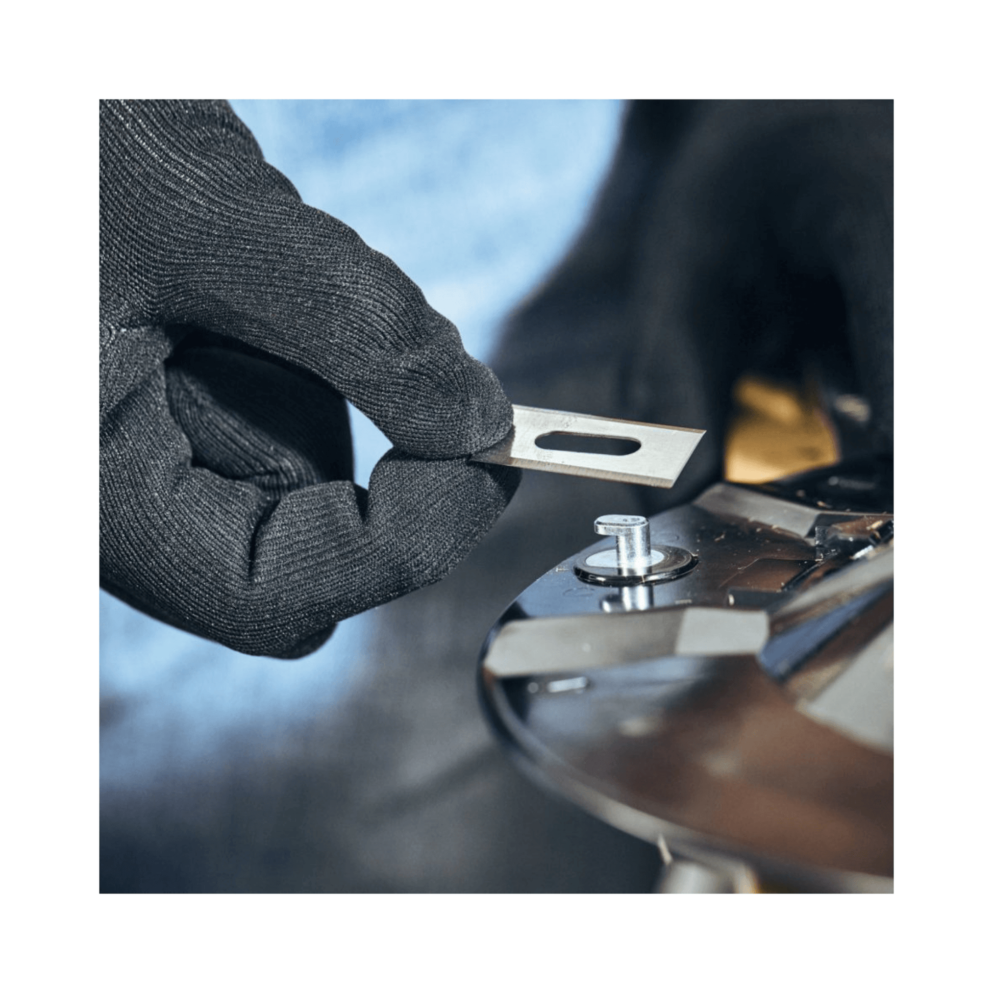 Hands in gloves installing a STIHL iMOW® DURO PLUS blade on a robotic mower for enhanced performance.
