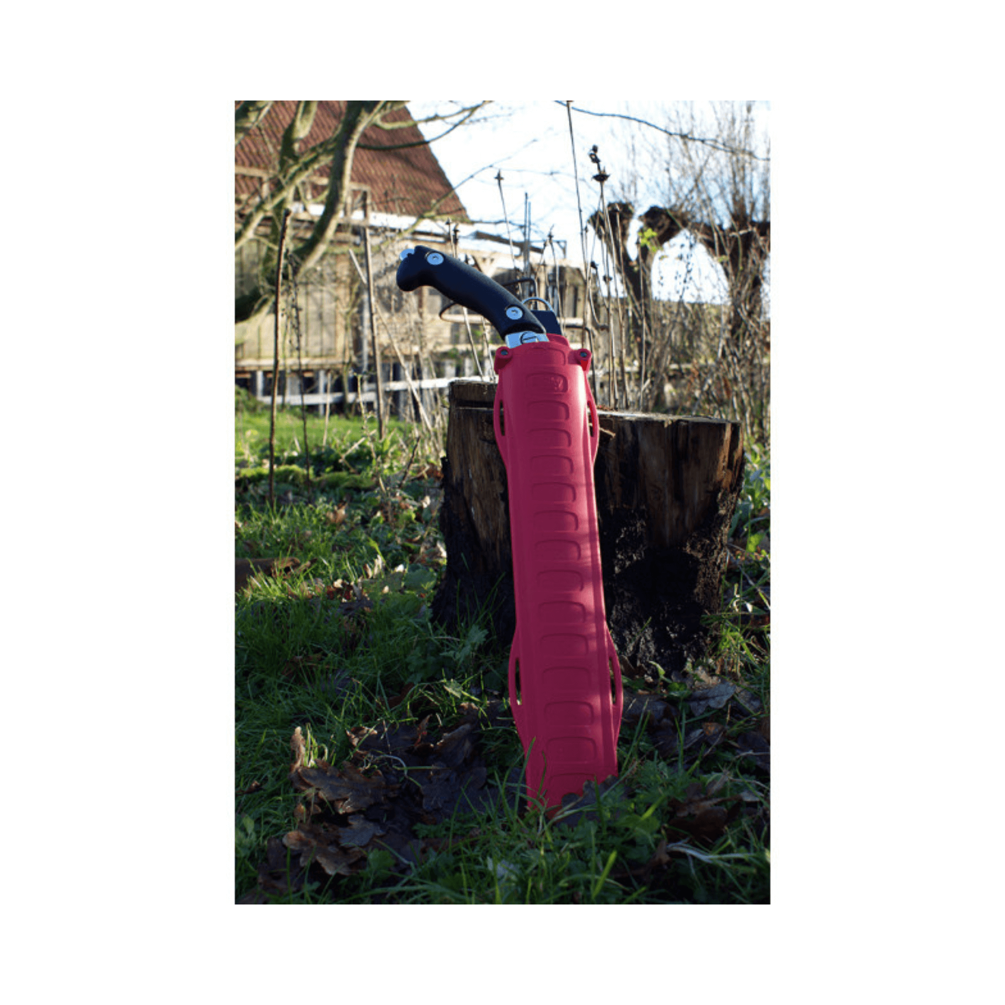 Ibuki Hand Saw 390mm standing next to a tree stump in a garden setting, ideal for tree surgeons.