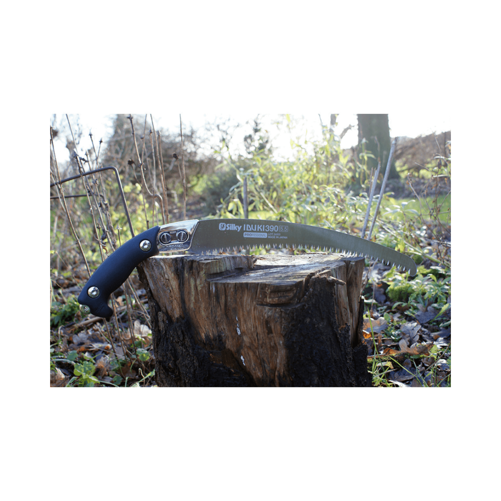Ibuki Hand Saw 390mm displayed on a log, showcasing its curved blade and ergonomic handle for tree surgeons.