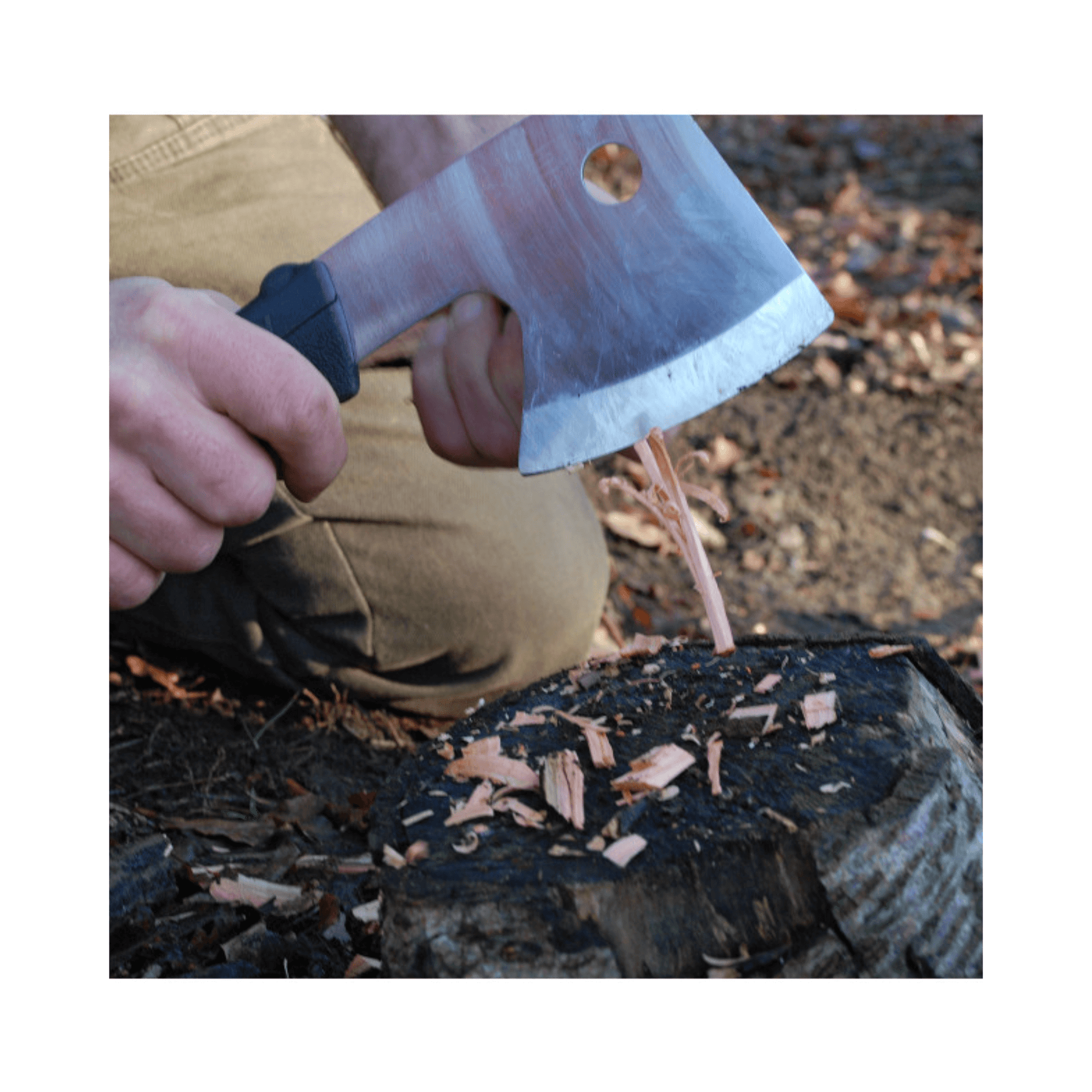 Close-up of a person using the Ono 120 Axe for precise chopping on a log, showcasing controlled outdoor skills.