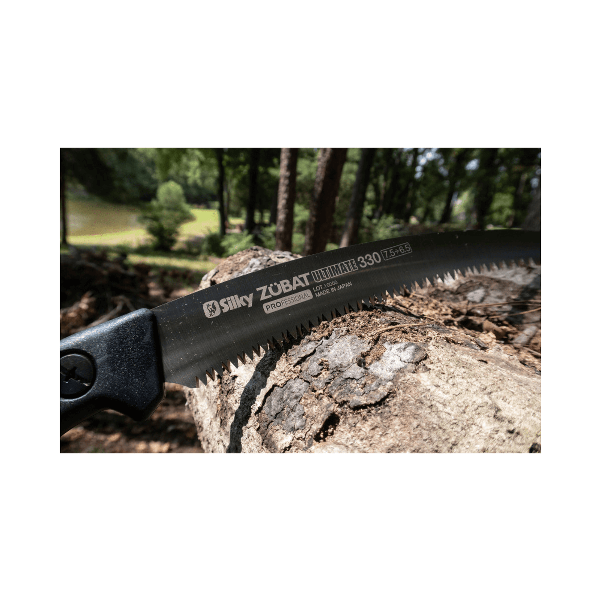 Silky Zubat Ultimate Pruning Saw 330mm blade on a log in a forest setting, ideal for tree surgeons.