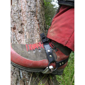 Spikepod climbing spike ratchet system attached to a boot against a tree trunk, ideal for tree surgeons.