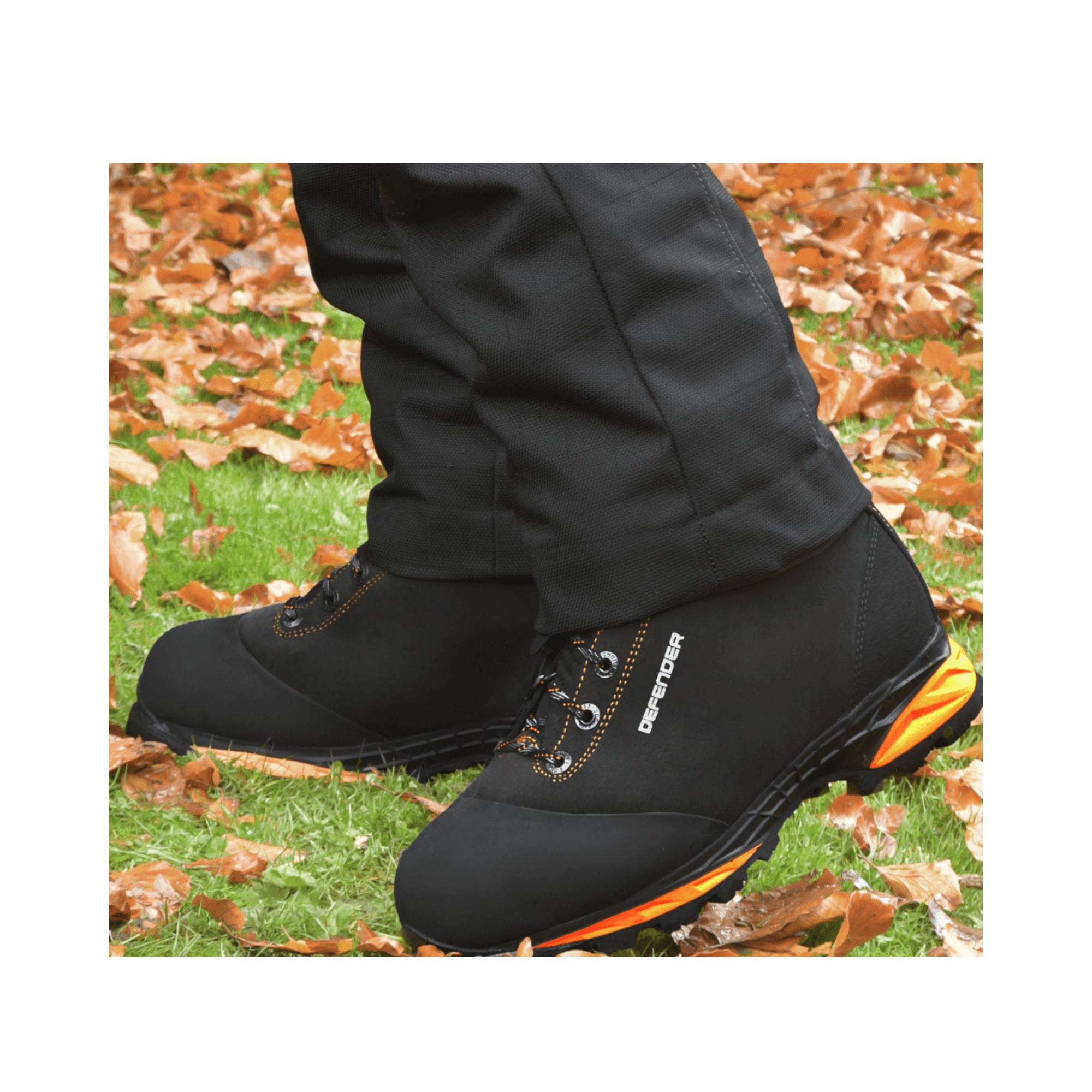 DEFENDER V2 Black Chainsaw Boots Class 2 shown on feet in an outdoor setting with fallen leaves.