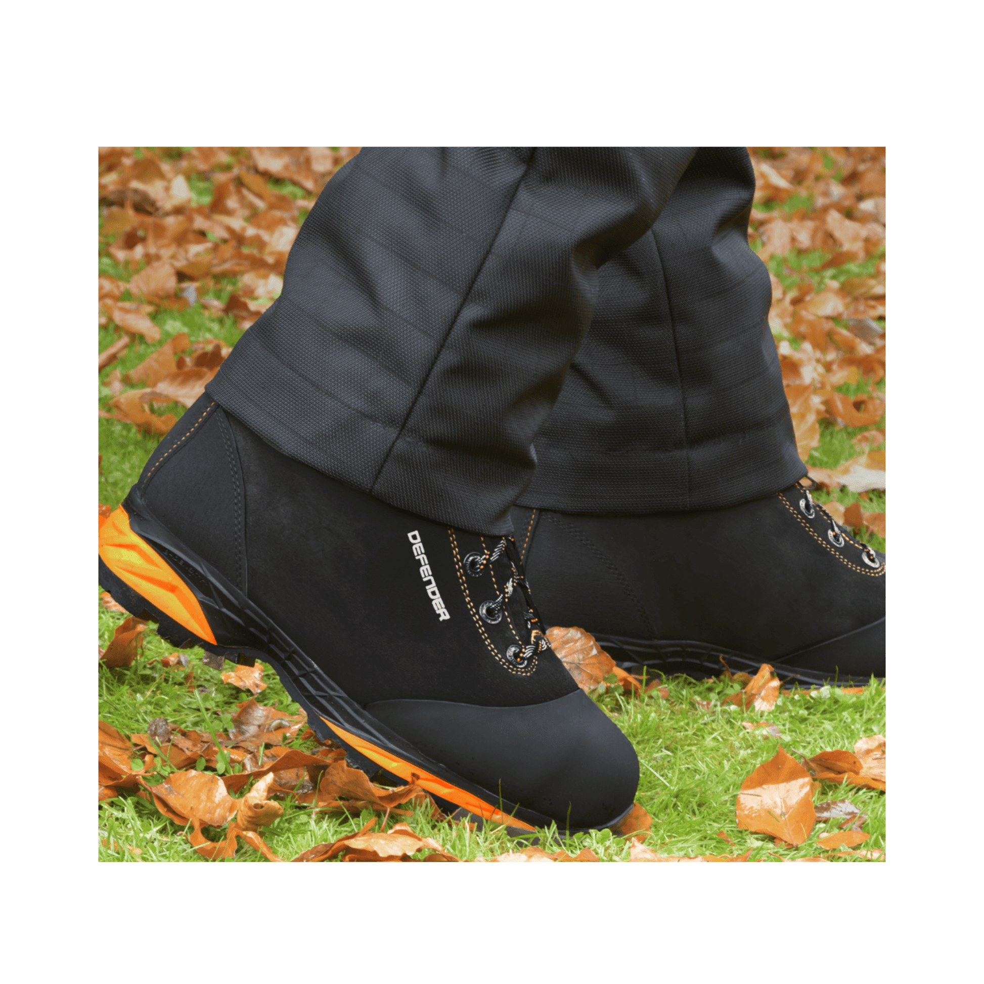 DEFENDER V2 Black Chainsaw Boots Class 2 worn in outdoor setting with autumn leaves on the ground.