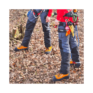 Two tree surgeons wearing Sentinel Chainsaw Trousers Type C in a forest setting, demonstrating safety and flexibility.