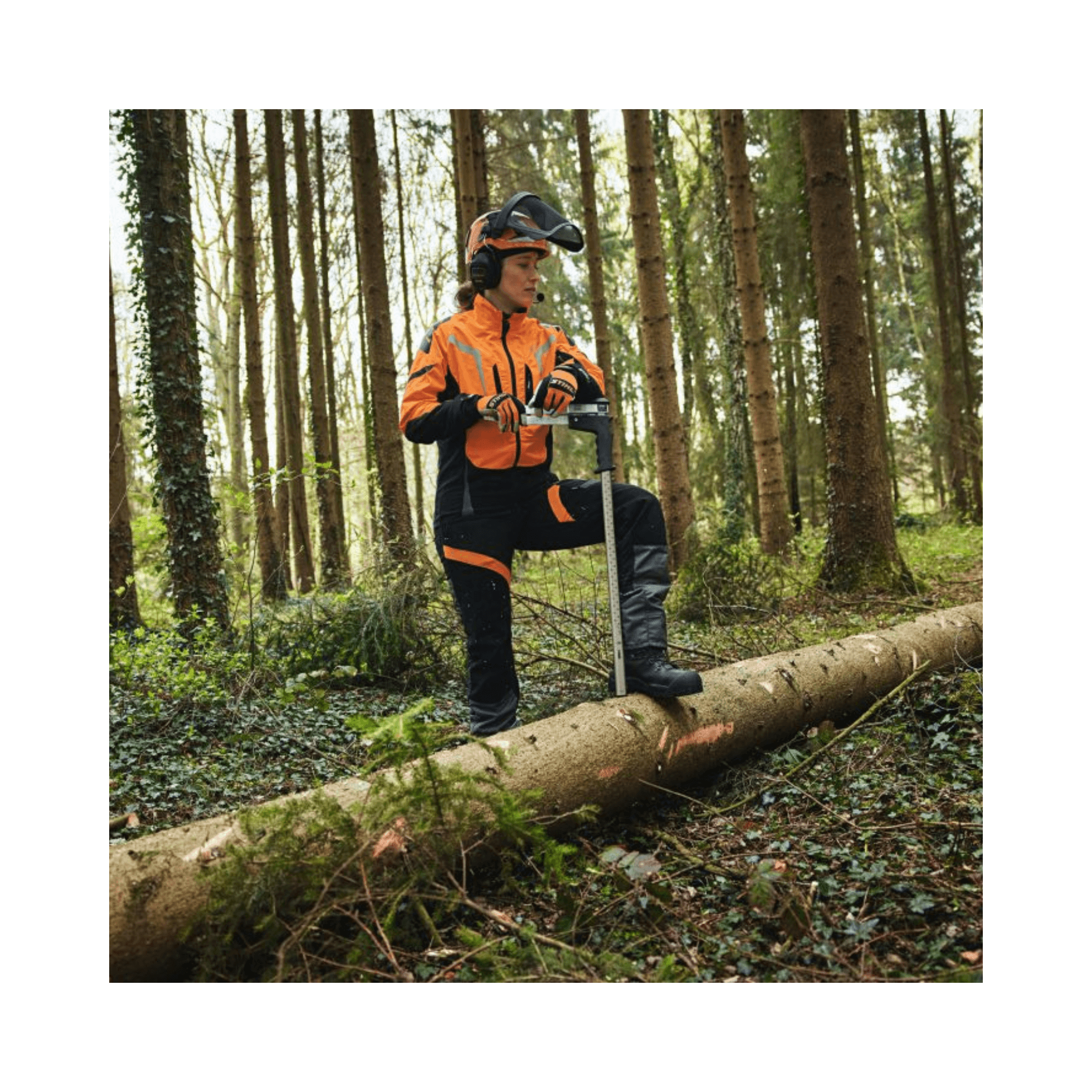 Tree surgeon wearing ADVANCE X-LIGHT Chainsaw Trousers Type A, using a chainsaw in a forest setting.