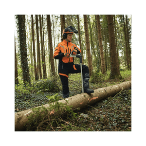 Tree surgeon wearing ADVANCE X-LIGHT Chainsaw Trousers Type A, using a chainsaw in a forest setting.