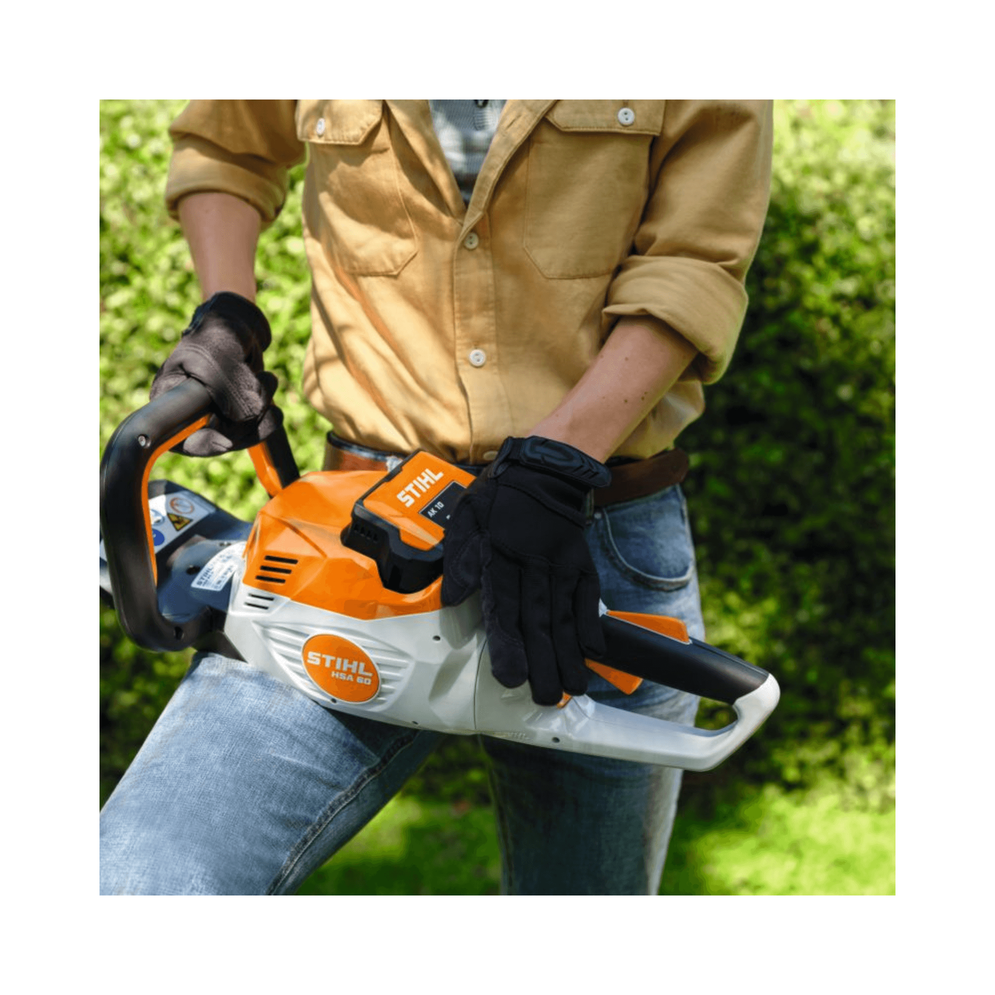 Person holding a STIHL battery-powered tool, wearing gloves, ideal for tree surgeons and outdoor maintenance.
