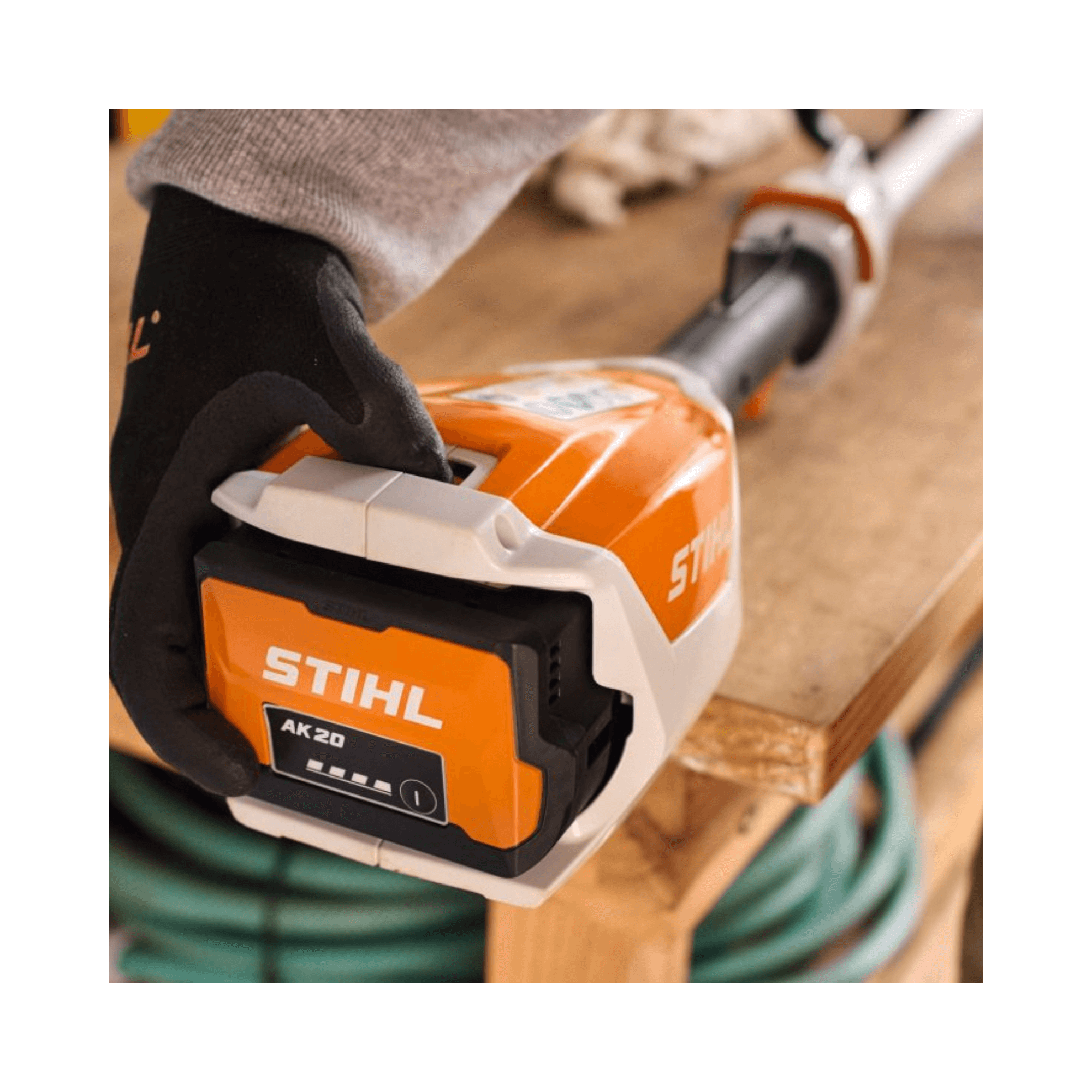 Close-up of a user holding the STIHL AK 20 Battery, featuring its robust design for gardening tasks.