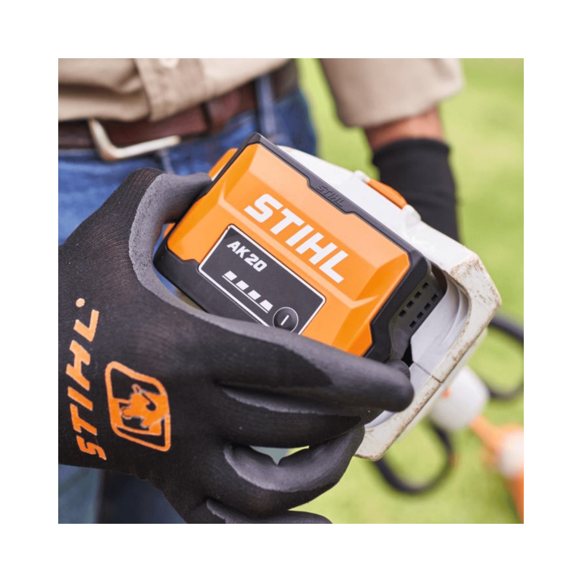 Person holding the STIHL AK 20 Battery while wearing gloves, demonstrating its lightweight and ergonomic design.