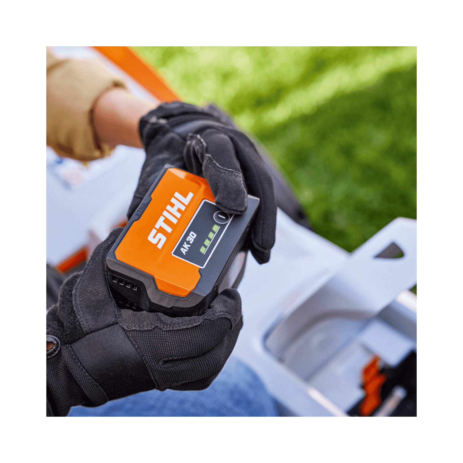 STIHL AK 30 S Battery held in gloved hands, ideal for tree surgeons and outdoor garden tools.