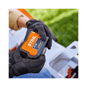 STIHL AK 30 S Battery held in gloved hands, ideal for tree surgeons and outdoor garden tools.