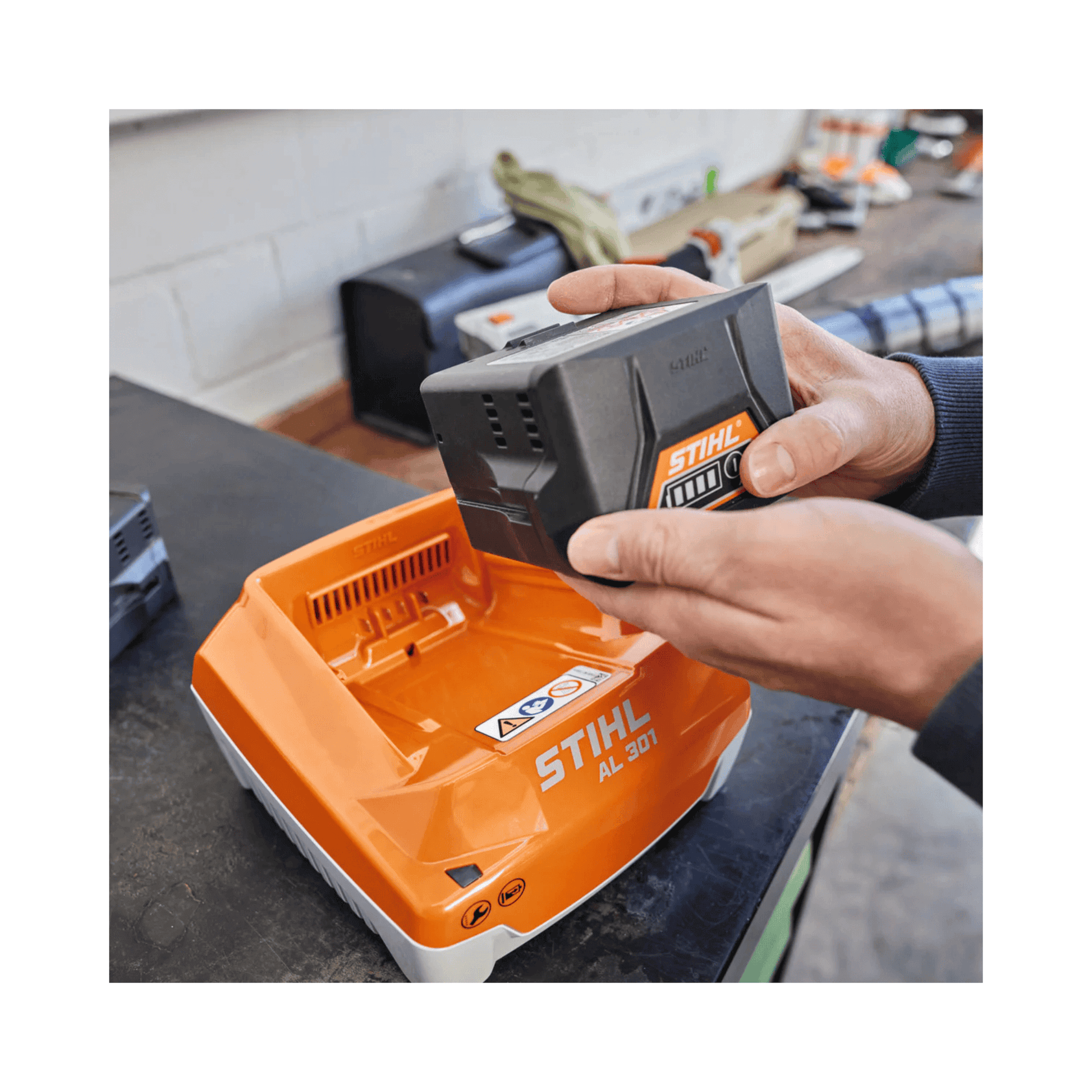 Person holding a STIHL battery pack in a workshop setting