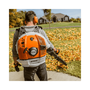 BR 600 Petrol Backpack Leaf Blower in use, clearing leaves in a yard with a professional-grade blower.