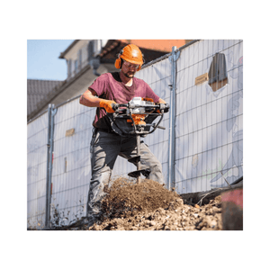 A worker using the BT 131 Petrol Earth Auger to drill into the ground for fence posts or planting.