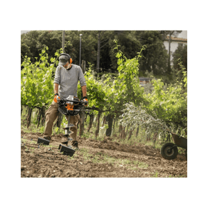User operating a BT 131 Petrol Earth Auger in a vineyard for efficient drilling.