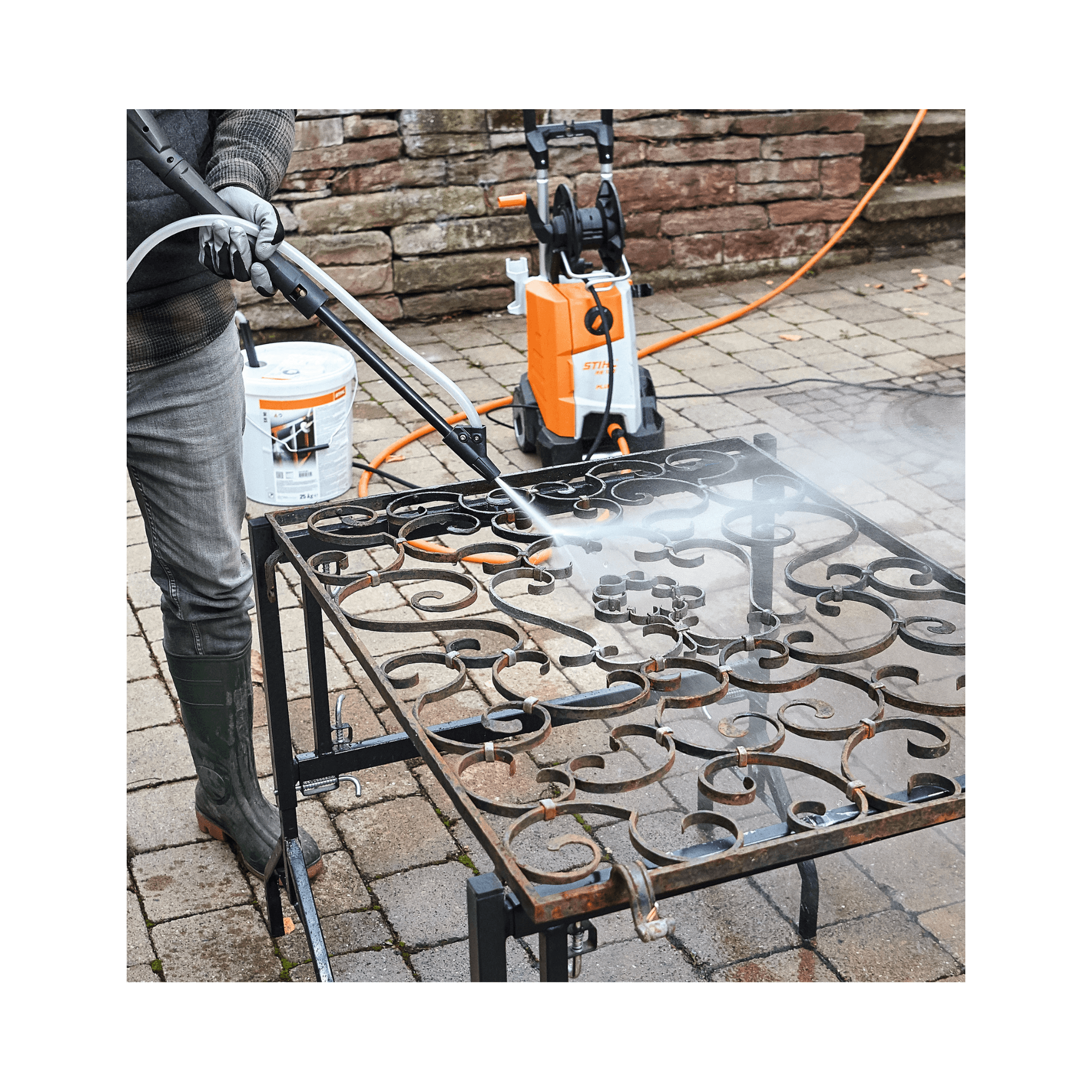Person using STIHL pressure washer with Blasting Granulate SB 90 on a metal surface outdoors.