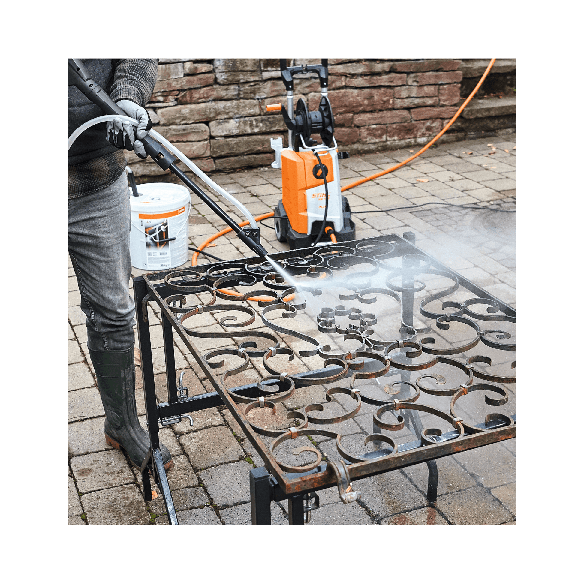 Person using STIHL pressure washer with Blasting Granulate SB 90 on a metal surface outdoors.