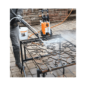 Person using STIHL pressure washer with Blasting Granulate SB 90 on a metal surface outdoors.