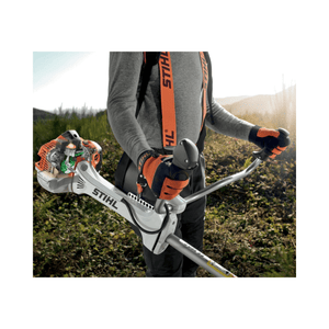 STIHL FS 491 C-EM petrol clearing saw held by an operator in a landscape, showcasing its ergonomic design and power.