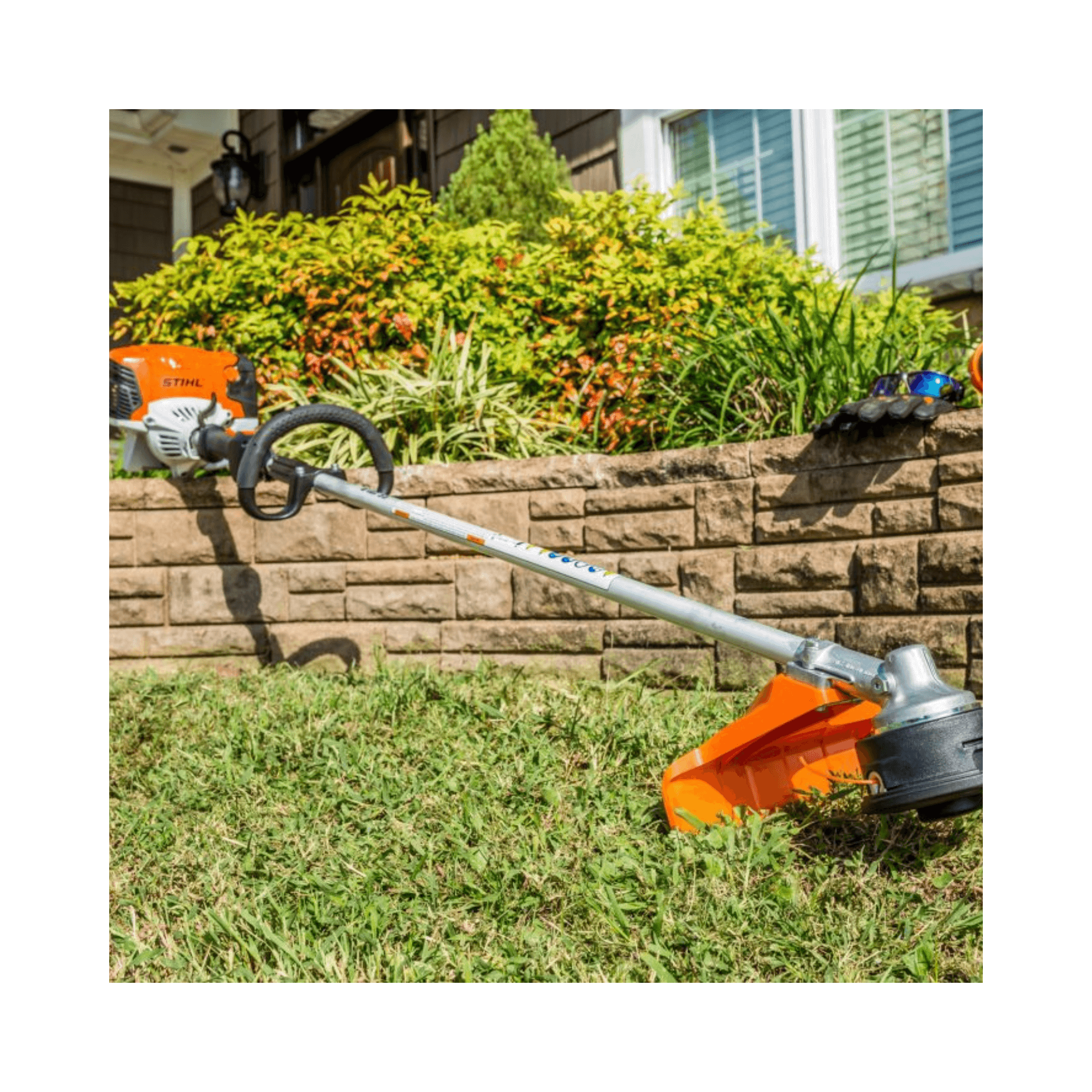 FS 131 R Petrol Brushcutter resting on grass with landscaping in the background, ideal for tree surgeons.