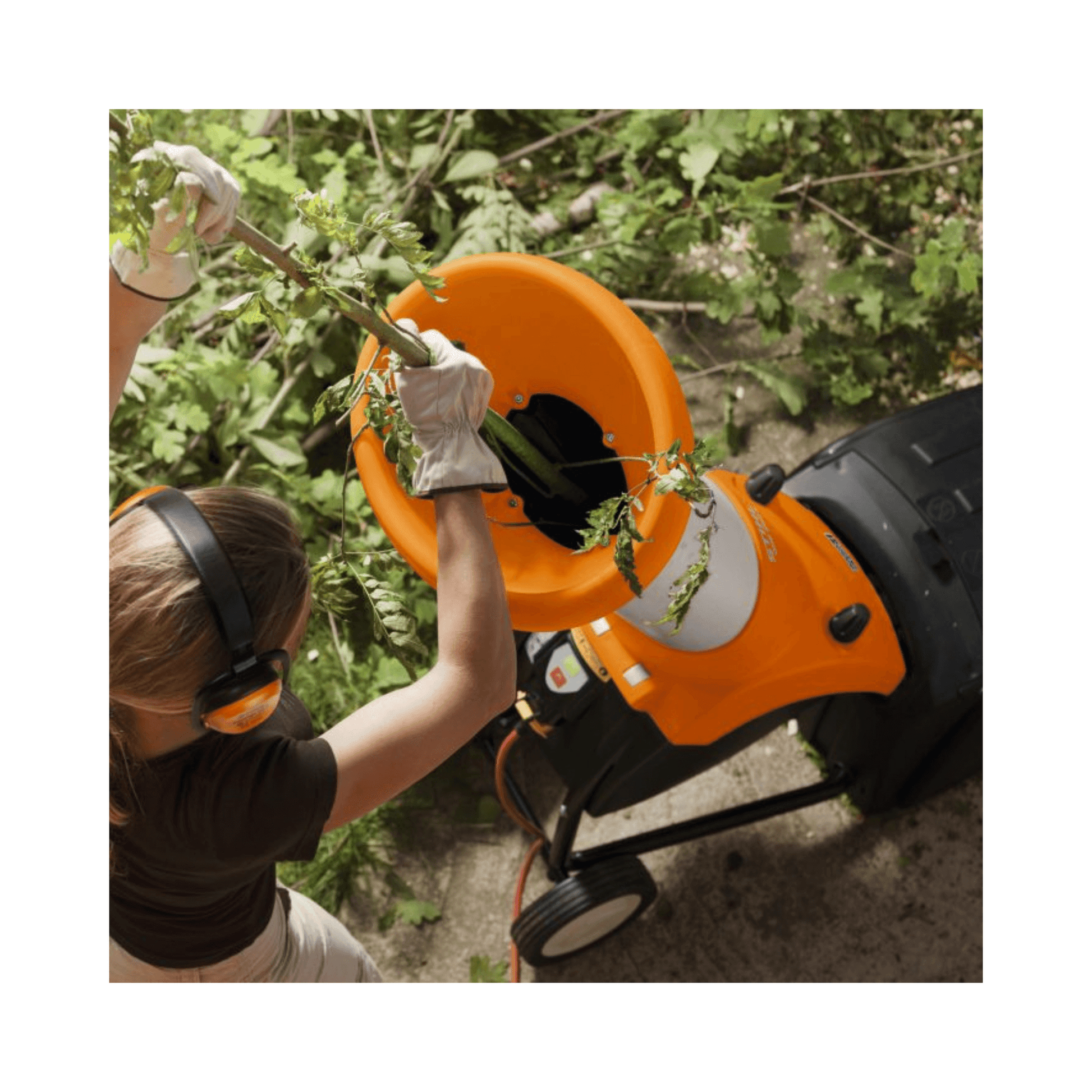 User operating the GHE 250 Electric Chipper Shredder, efficiently processing garden waste.