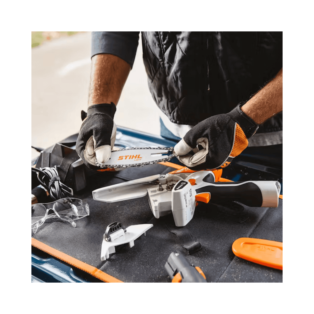 STIHL GTA 26 cordless pruning saw with accessories on a workbench for tree surgery.
