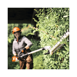 HLA 140 Cordless Long-Reach Hedge Trimmer used by a tree surgeon for precise hedge trimming.