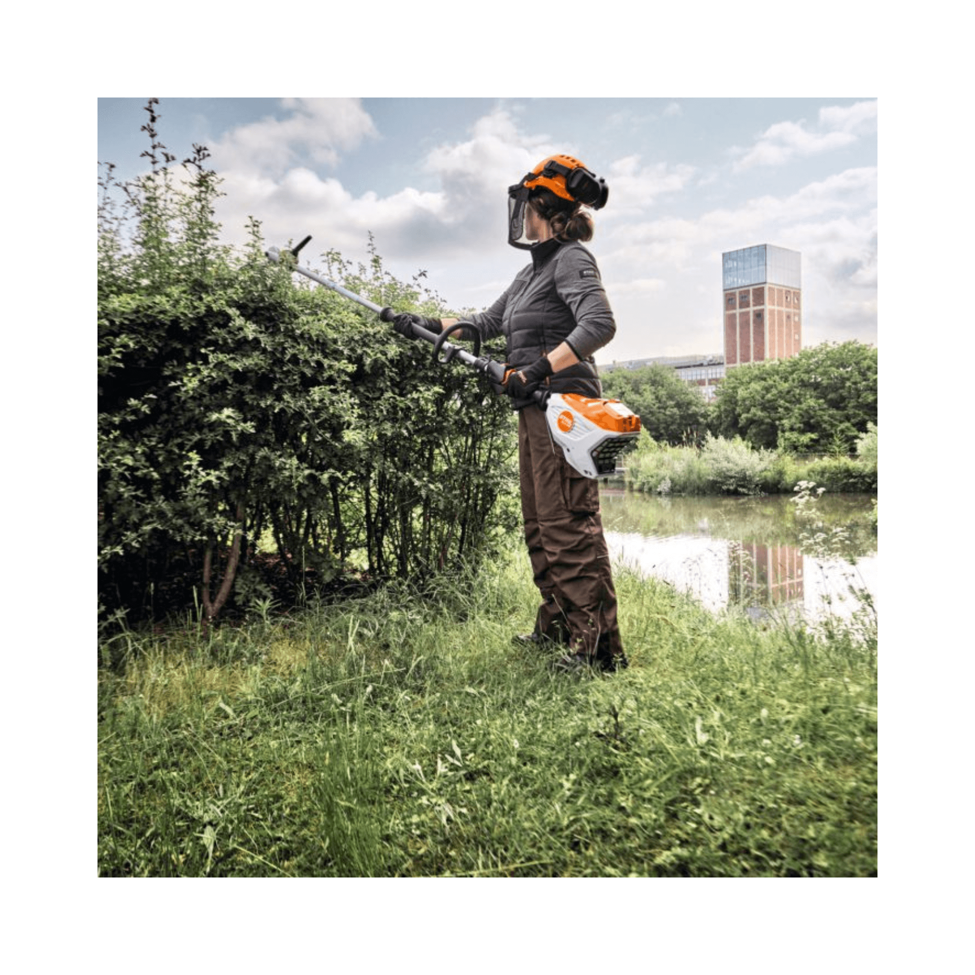 Person using HLA 140 Cordless Long-Reach Hedge Trimmer for professional landscaping and maintenance.