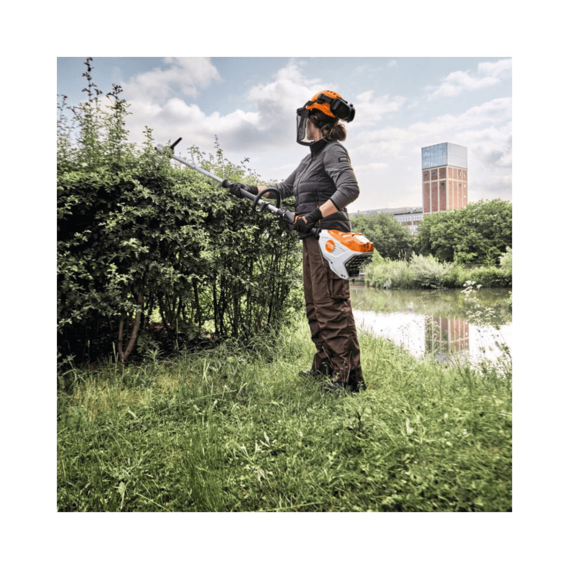 Person using HLA 140 Cordless Long-Reach Hedge Trimmer for professional landscaping and maintenance.