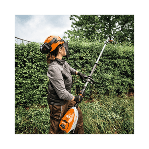 Woman using HLA 140 Cordless Long-Reach Hedge Trimmer for maintaining tall hedges.