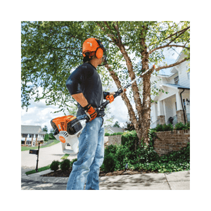 Professional tree surgeon using a STIHL HT 135 petrol pole pruner for efficient tree maintenance.